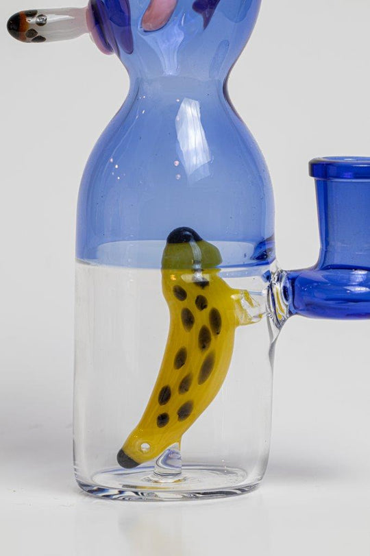 7 inch Smoking Monkey Water Pipe – a whimsical addition to your weed and dab collection in water bong style glass. For sale now, this unique water bottle-shaped piece includes a 14MM male bowl and a banana-shaped bent down stem. The integrated percolator ensures a smooth smoking experience, preventing water splashback, cooling the smoke down, and providing extra filtration