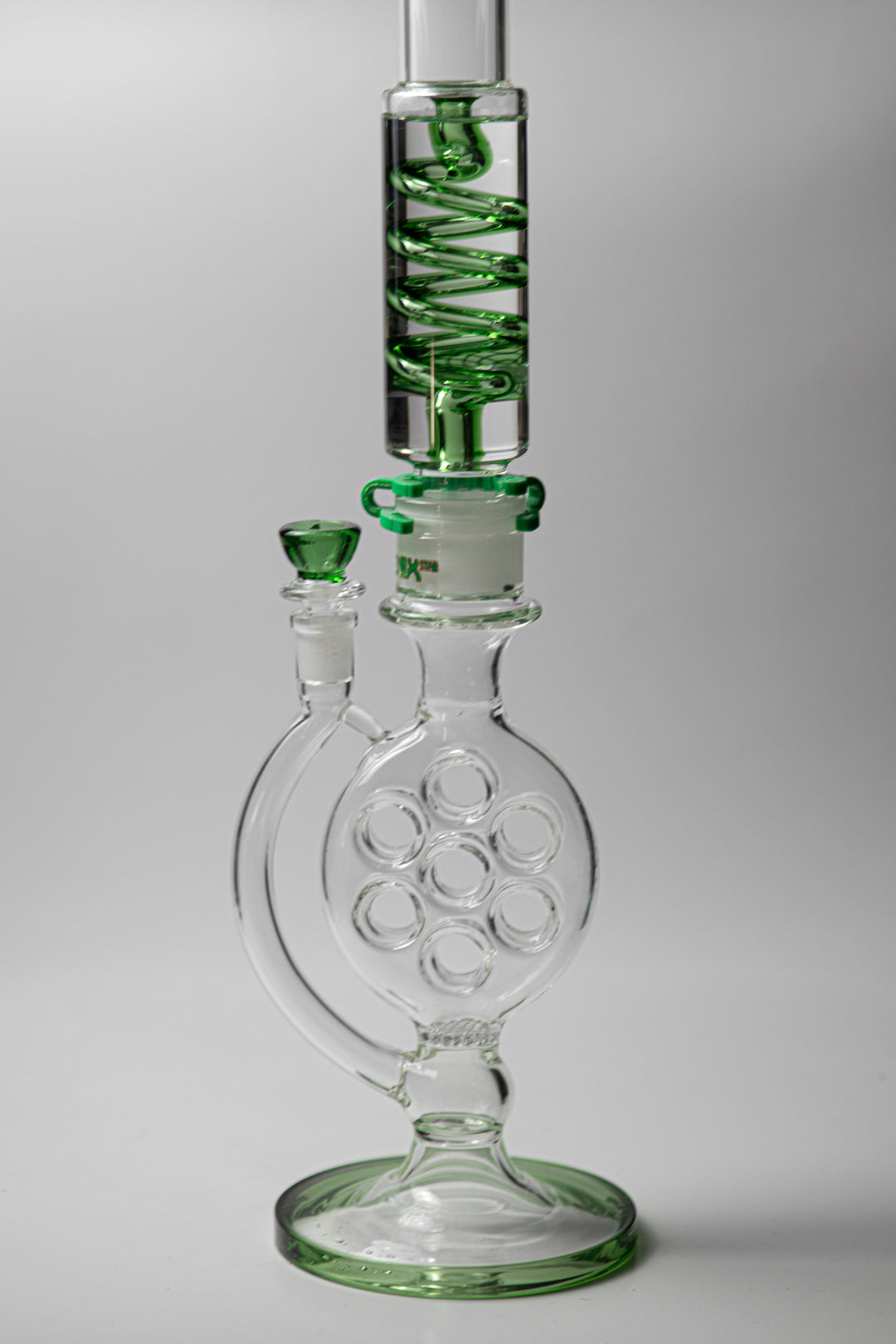 Phoenix Swiss Divided Green Water Pipe – a 21-inch rig for weed and dabs. Now available for sale, this standout piece boasts a striking design, a bowl piece for weed, a bent-down stem, recycler percolator, and a small honeycomb percolator. The incorporated percolators ensure a smooth, cool smoke, preventing water from splashing back . Color green 