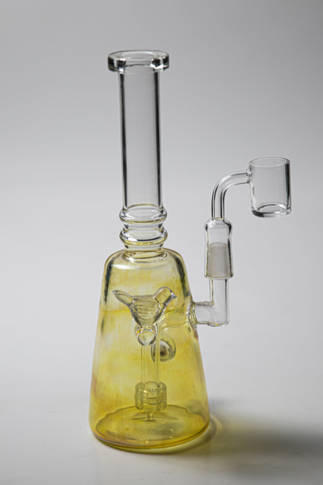 Yellow Bird Rig – an 8-inch water pipe crafted for weed and dabs. Now available for sale, this unique piece boasts a Yellow Bird design, a female banger for dabs, and a bent-down stem bubbler,The included percolator prevents water from splashing back into your mouth, cools the smoke down, and adds extra filtration, 